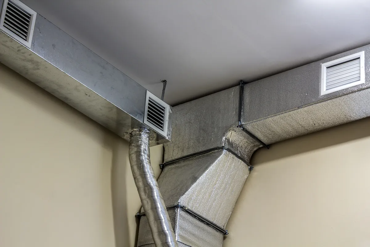 A detailed view of an industrial-style ventilation system featuring metal ducting and flexible insulated pipes in a Los Angeles property.