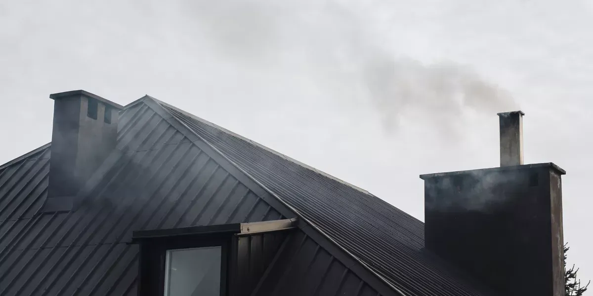 Technician inspecting chimney flashing for leak source